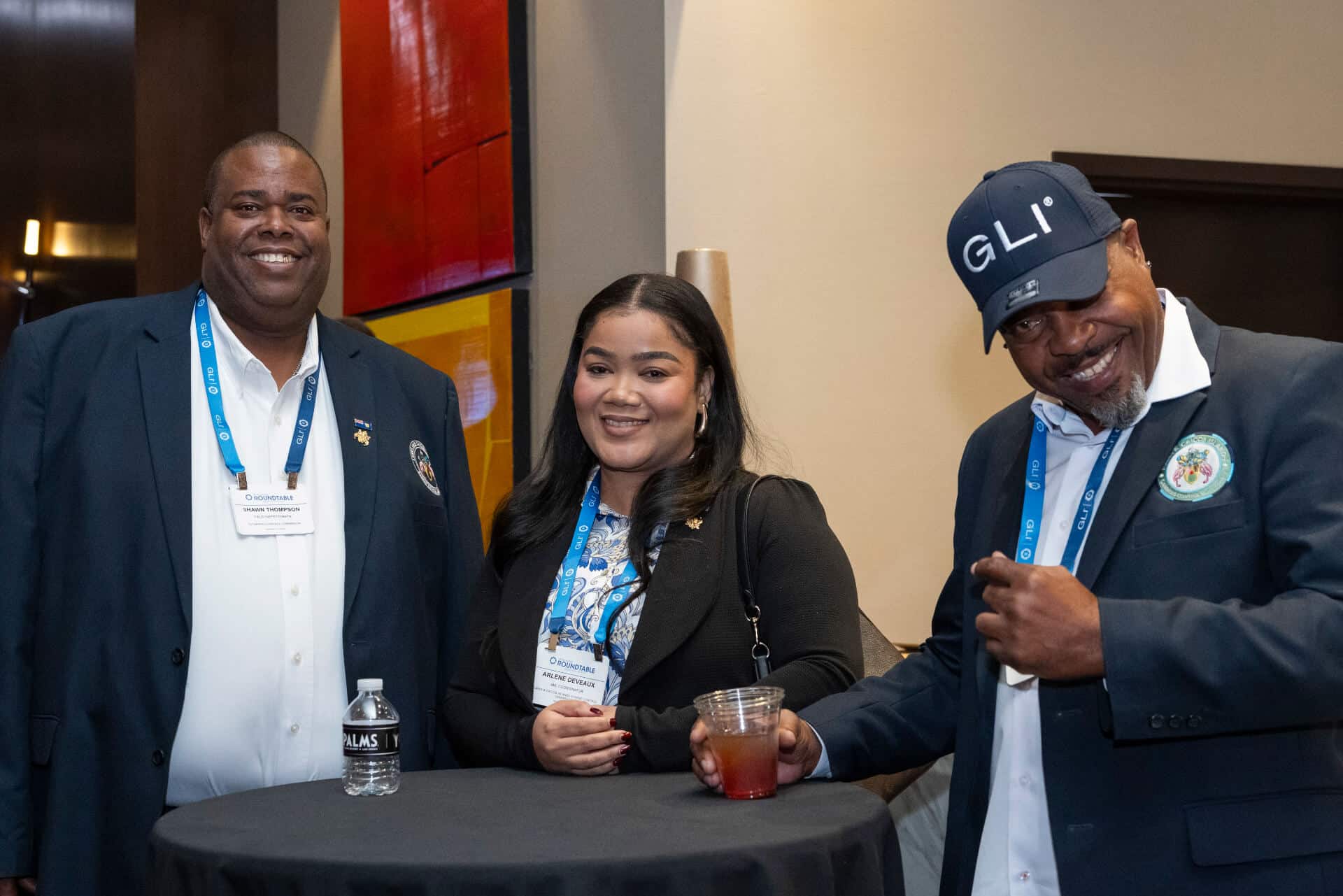 Three Regulators Roundtable attendees stand around a high-top table, smiling and networking during reception.